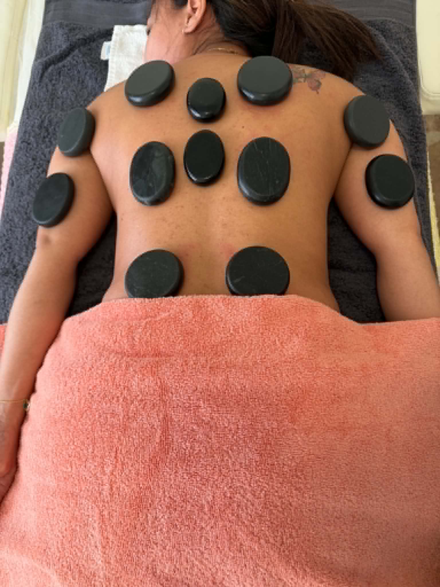 Relaxation treatment with heated stones on the back